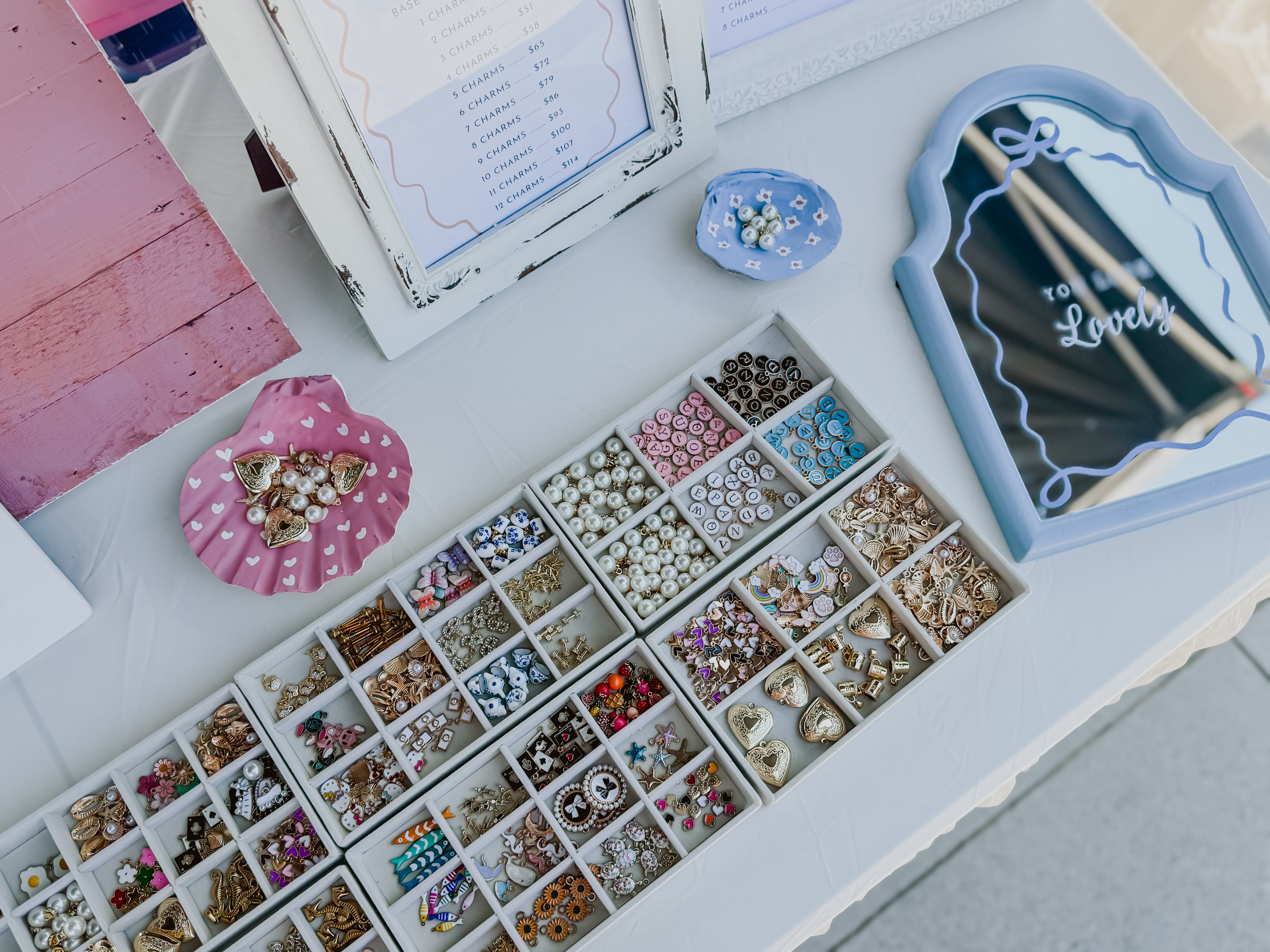 Assorted jewelry findings in a box with decorative items on a white surface